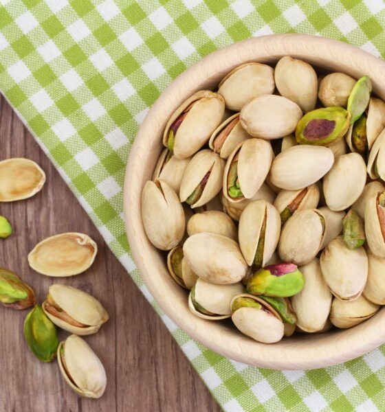 Pistachio nuts in wooden bowl with copy space